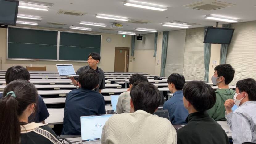 多数の新入部員が教室でPCを開き、メールの書き方について、上級生の話を聞いている様子